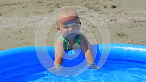 The child is playing in the inflatable pool in the water