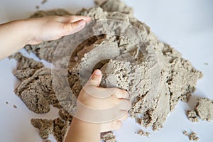 Child playing with kinetic sand. Baby`s sensory experiences