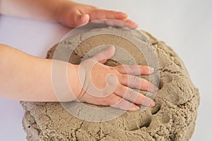 Child playing with kinetic sand. Baby`s sensory experiences