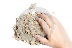 Child playing with kinetic sand. Hand of the child in the sand c