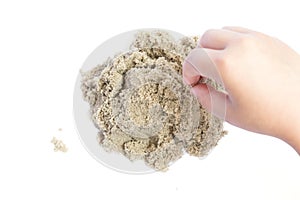 Child playing with kinetic sand. Hand of the child in the sand c