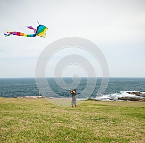 Child playing with a kite on a beach