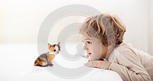 Child playing with kitten. Cat and kid at home