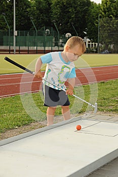 Child playing mini golf