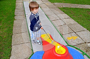 Child playing mini golf