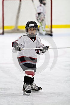 Child playing minor hockey in the arena