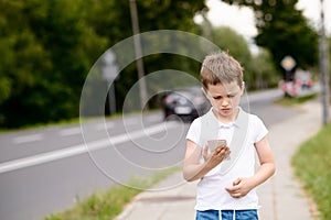 Child playing mobile games on smartphone on the street