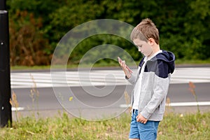 Child playing mobile games on smartphone on the street