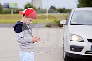Child playing mobile games on smartphone on the street