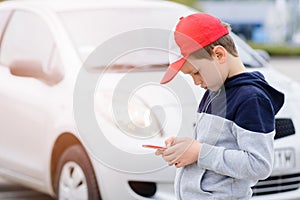 Child playing mobile games on smartphone on the street