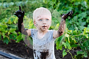 Child playing in the mud on the street