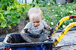 Child playing in the mud on the street