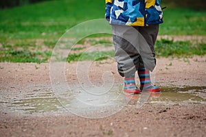 Child playing in muddy puddle