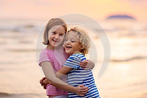 Child playing on ocean beach. Kid at sunset sea