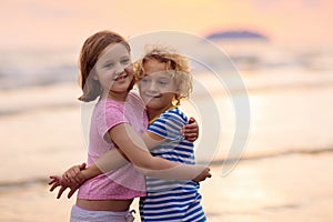 Child playing on ocean beach. Kid at sunset sea