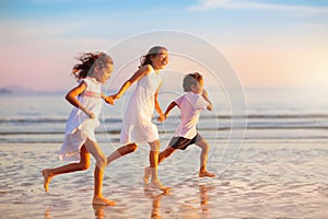 Child playing on ocean beach. Kid at sunset sea