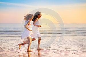 Child playing on ocean beach. Kid at sunset sea