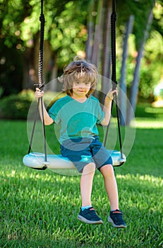 Child playing outdoor. Kids swing on backyard. Happy cute little boy swinging and having fun healthy summer vacation