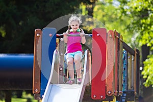 Child playing on outdoor playground in summer