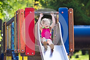 Child playing on outdoor playground in summer