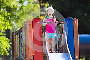 Child playing on outdoor playground in summer