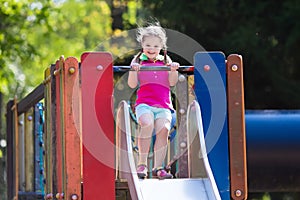 Child playing on outdoor playground in summer