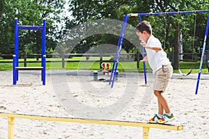 Child playing on the park play structure balance beam