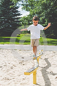 Child playing on the park play structure balance beam