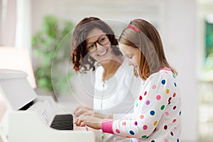 Child playing piano. Kids play music