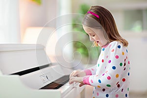 Child playing piano. Kids play music