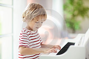 Child playing piano. Kids play music