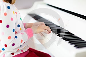 Child playing piano. Kids play music