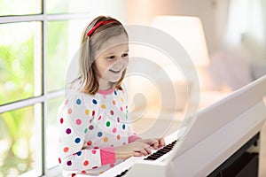 Child playing piano. Kids play music