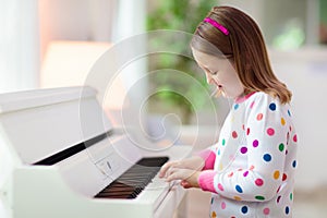 Child playing piano. Kids play music