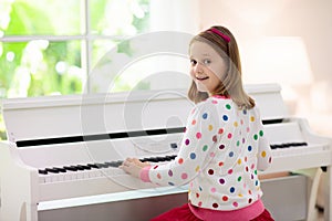 Child playing piano. Kids play music