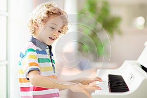 Child playing piano. Kids play music