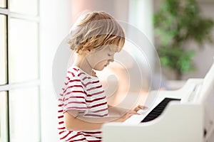 Child playing piano. Kids play music