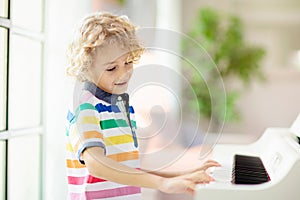 Child playing piano. Kids play music