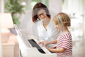 Child playing piano. Kids play music