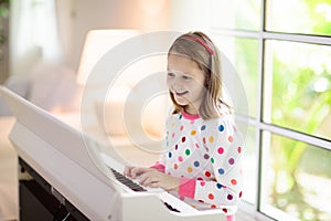 Child playing piano. Kids play music
