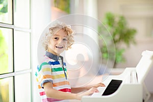 Child playing piano. Kids play music