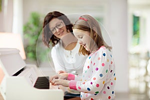 Child playing piano. Kids play music