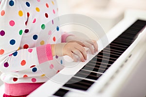 Child playing piano. Kids play music