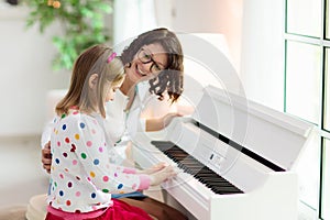 Child playing piano. Kids play music photo