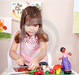 Child playing with plasticine in school. photo