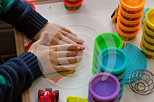 A child playing with Play Doh modelling clay at a table