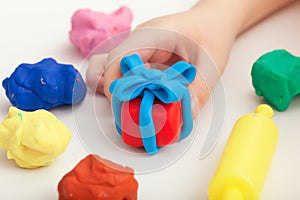 Child playing with playdough and making a giftbox photo