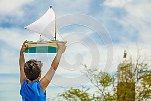 Child playing with pleasure boat on the beach photo