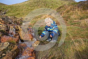 Child playing on a pond in geothermal area in Krysuvik on early sunny morning, Southern Peninsula Reykjanesskagi, Reykjanes