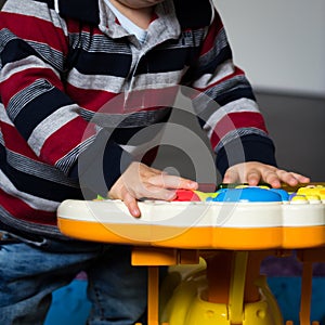 Child playing pressing the buttons of his electronic game